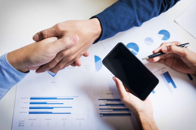 Profissionais em reunião comercial analisando dados de vendas e fechamento de negócio em operação B2B com CRM